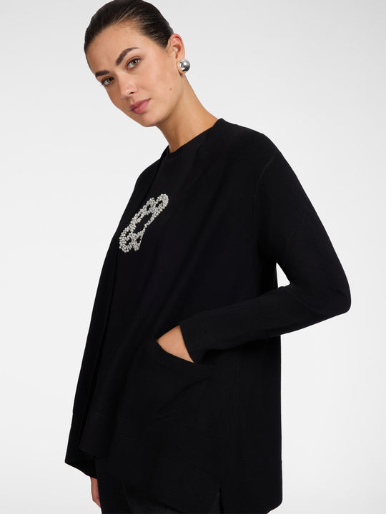Black flared cardigan side view with open front and pocket detail