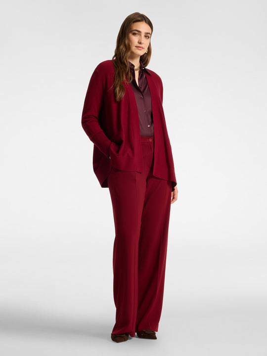 Red flared cardigan with pockets, open front, and long sleeves