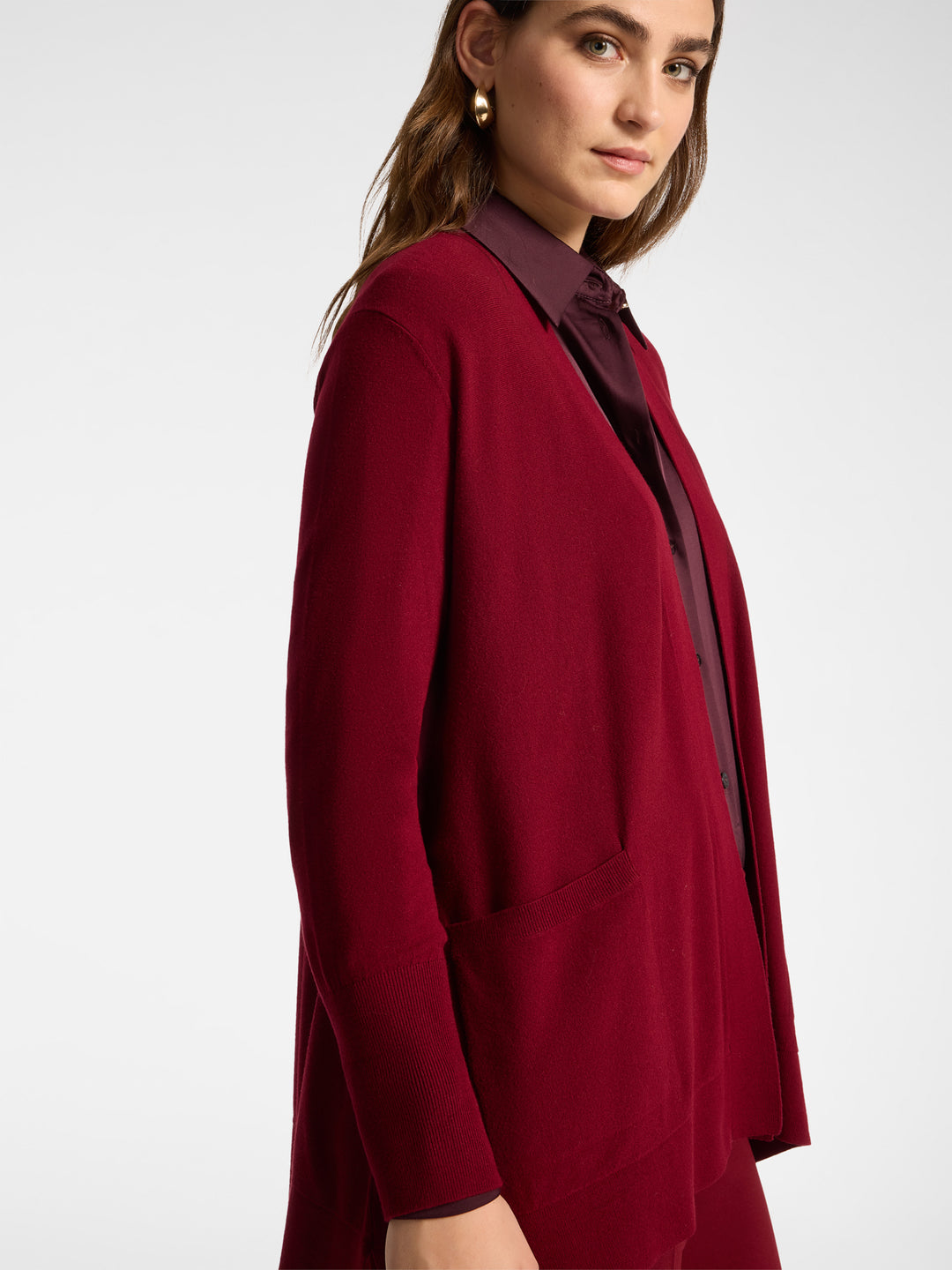 Red draped cardigan with open front, long sleeves, and side pocket detail