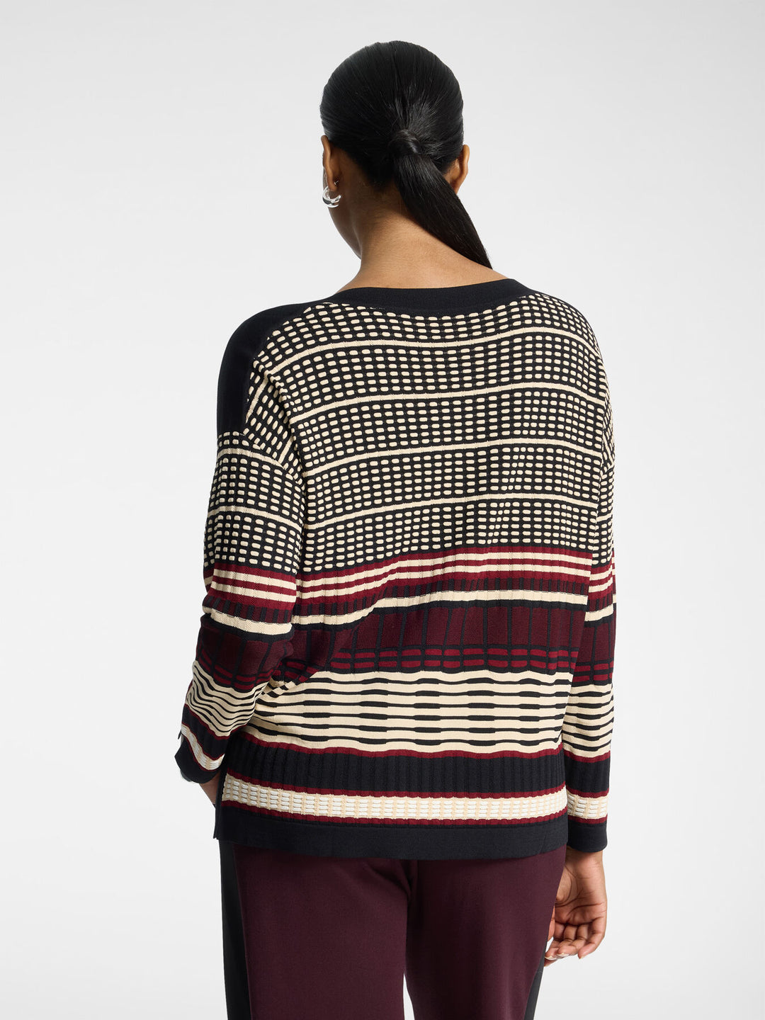 Striped jacquard pullover back view, black base with cream grid stripes and dark red band