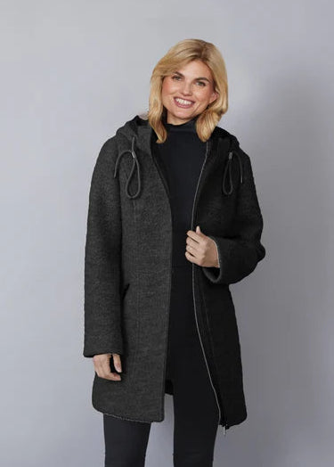 Woman wearing a dark gray coat against a plain background