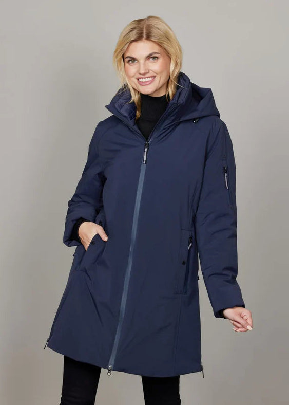 Woman wearing a navy blue coat against a plain background