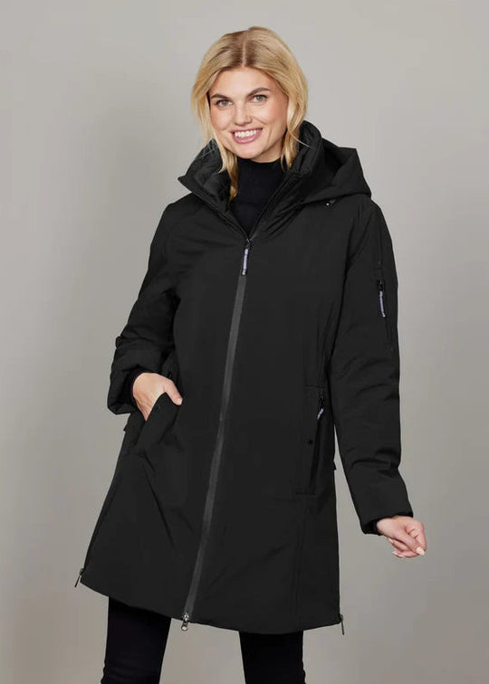 Woman wearing a black coat against a gray background