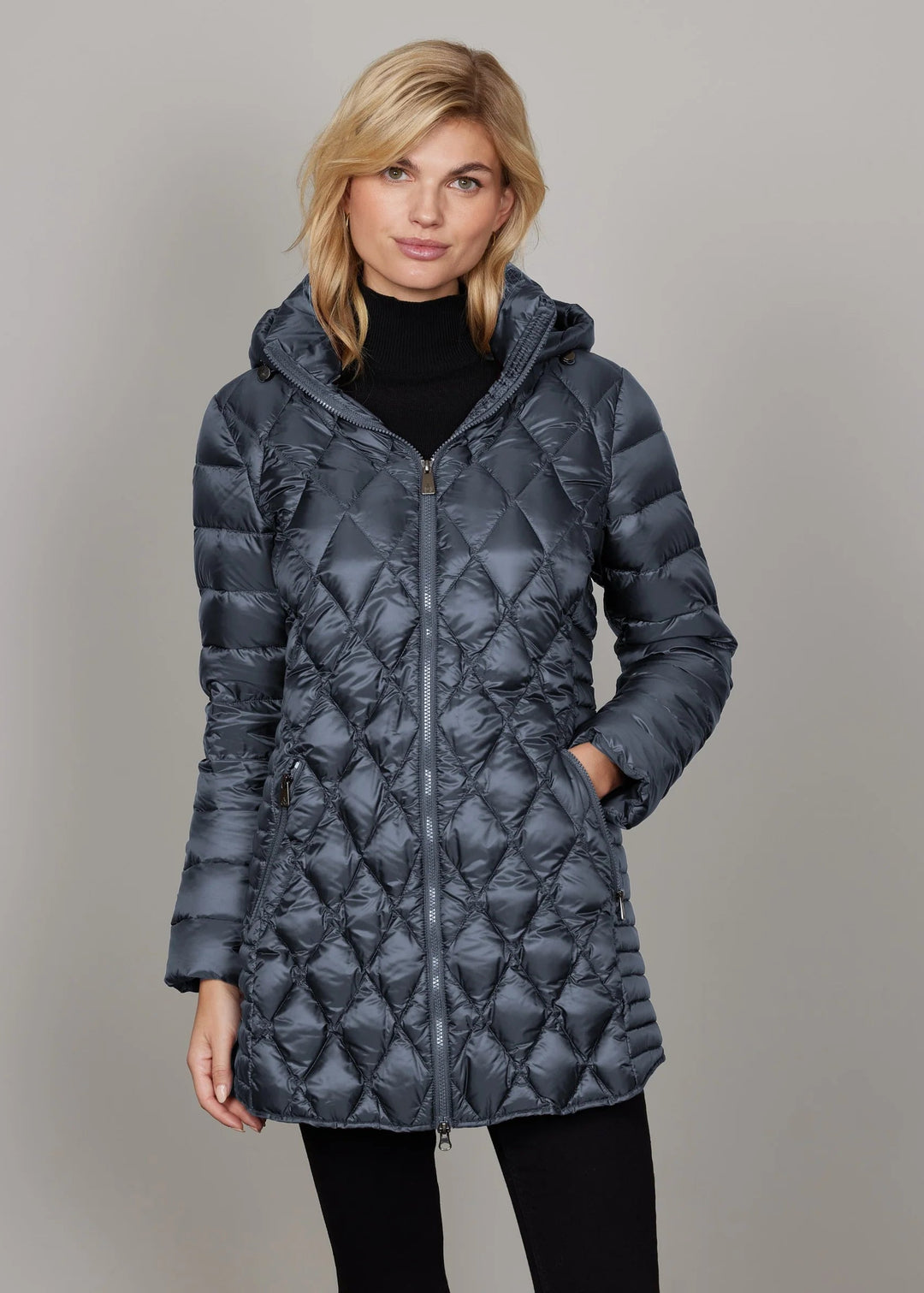 Woman wearing a blue quilted jacket against a plain background