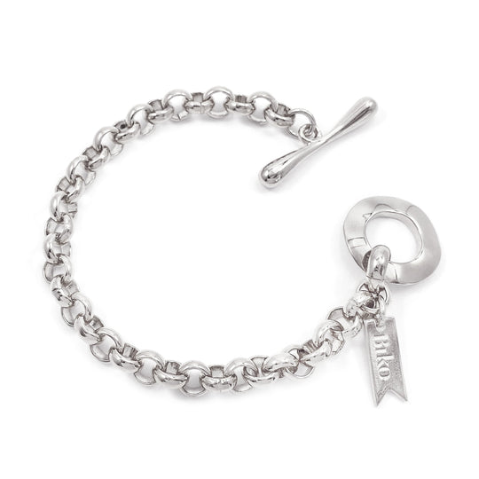 Chain link bracelet with toggle clasp and small banner charm on white background