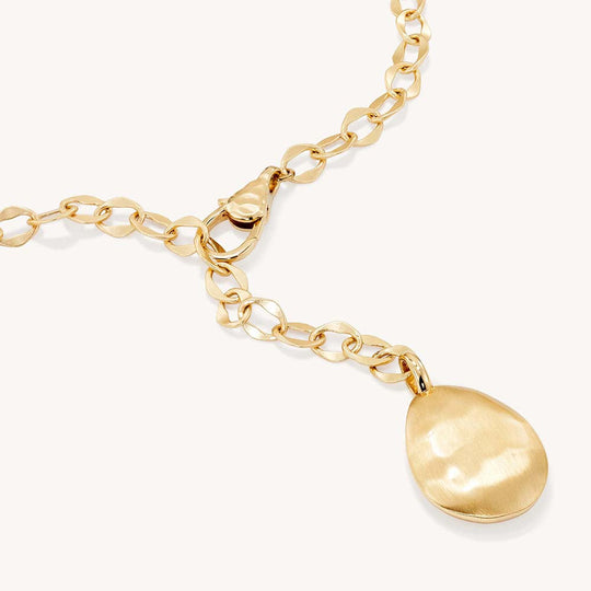 Gold chain lariat necklace with oval curb links, lobster clasp, and brushed teardrop pendant