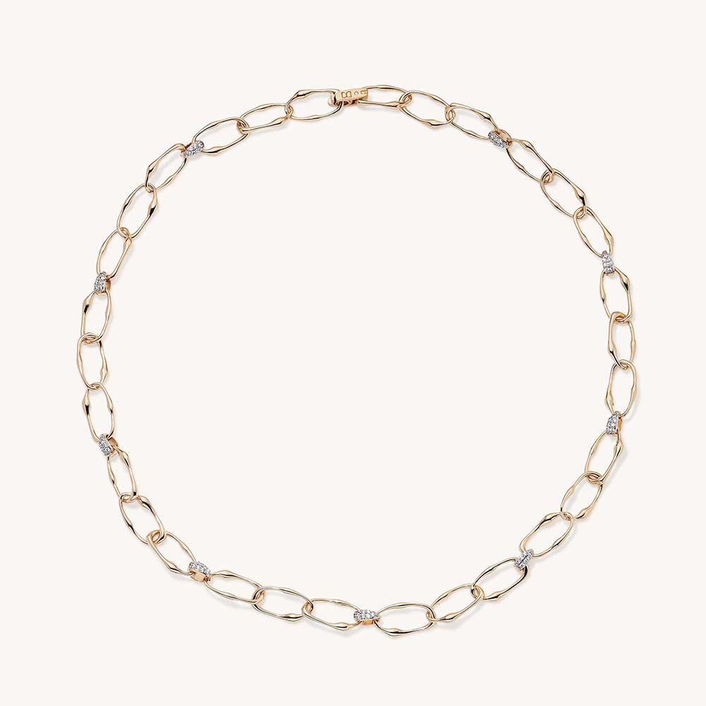 Gold oval link chain necklace with diamond pavé connectors, displayed in circular shape