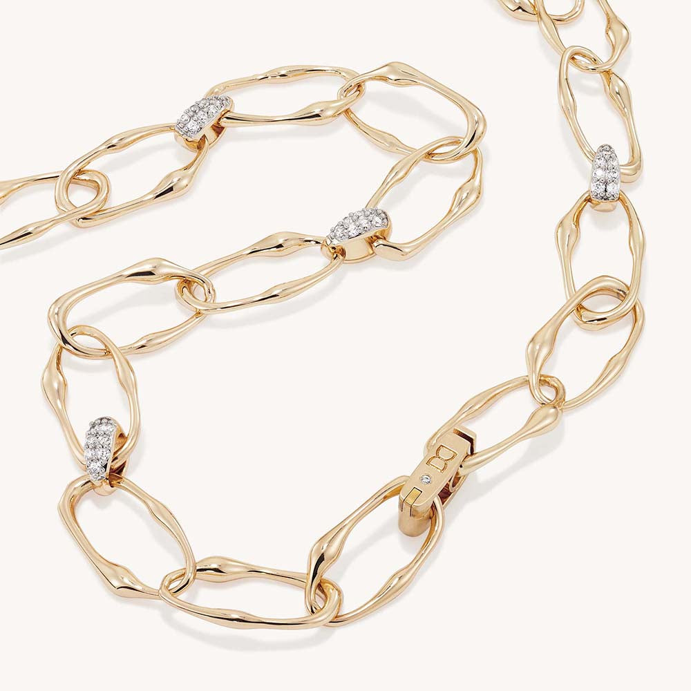 Gold chain link necklace with organic oval links and pavé diamond connectors, flatlay view
