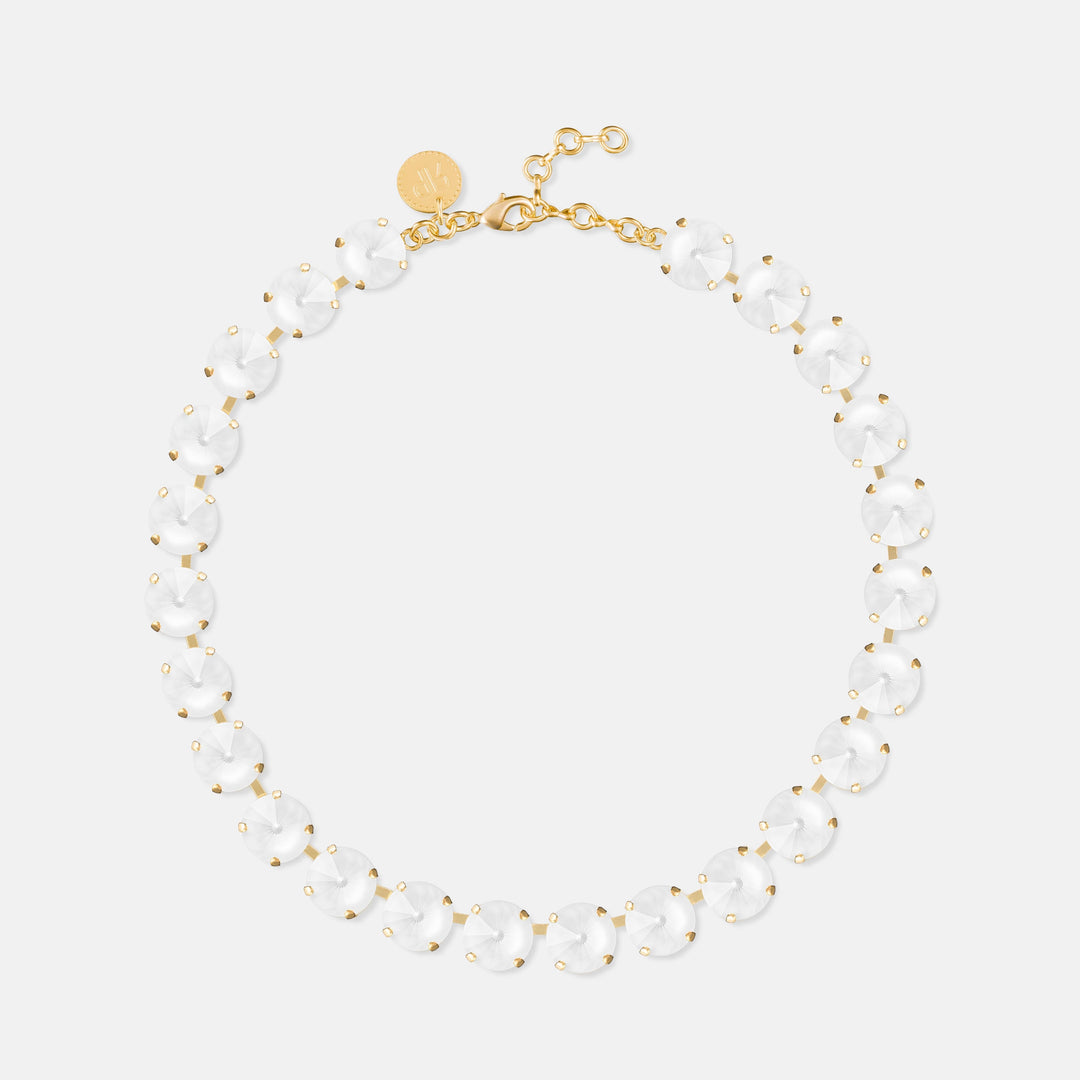 Gold necklace with repeating clear oval stones and white beaded accents, clasp closure