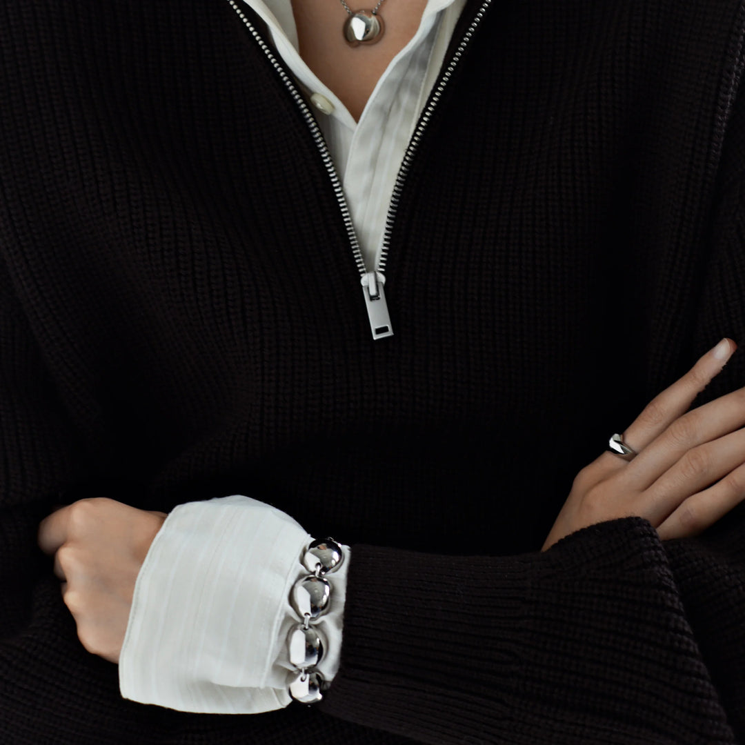 Silver ball-link bracelet worn on cuff with round links and clasp detail