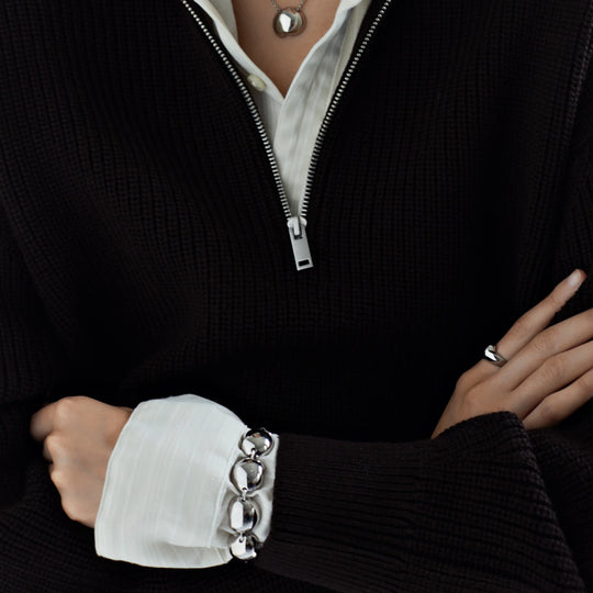 Silver ball-link bracelet worn on cuff with round links and clasp detail
