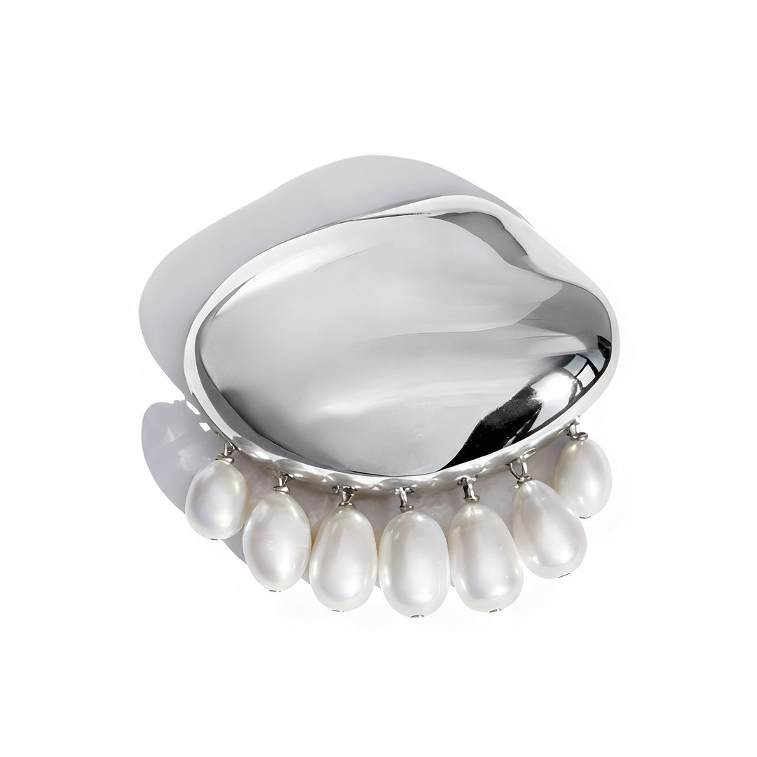 Silver curved brooch with dangling white pearl drops on clean background