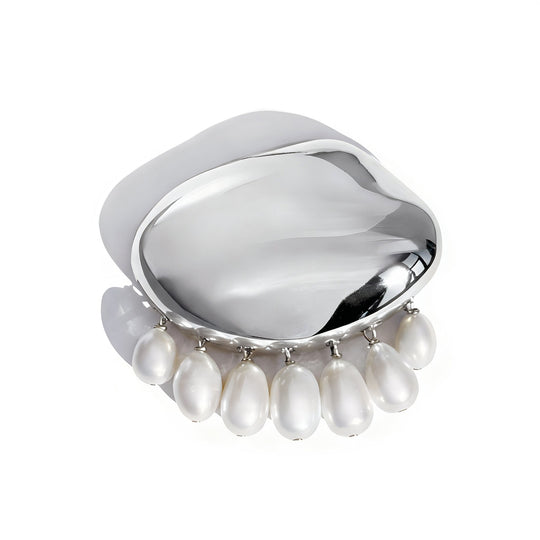 Silver curved brooch with dangling white pearl drops on clean background