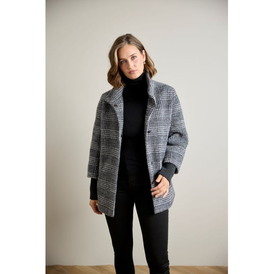 Glen plaid open-front coat with ribbed sleeve cuffs, worn over black turtleneck and pants, front view