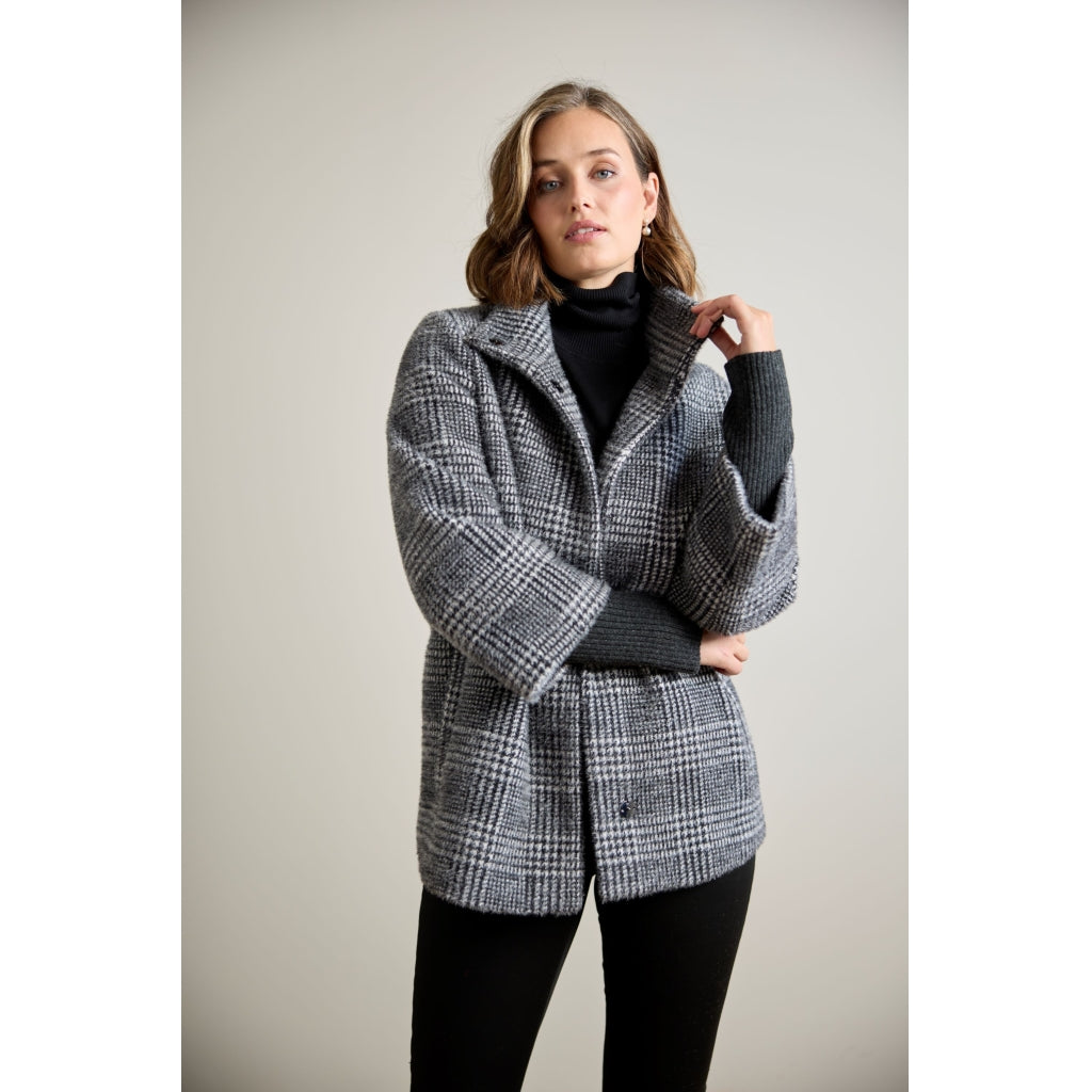 Glen plaid oversized coat with contrast ribbed knit sleeves, worn open over black turtleneck
