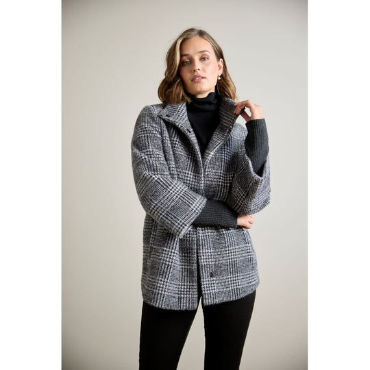 Glen plaid oversized coat with contrast ribbed knit sleeves, worn open over black turtleneck