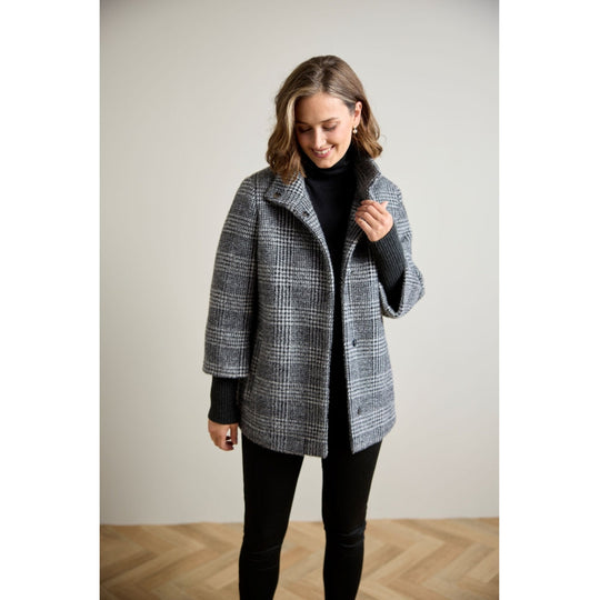 Glen plaid wool coat with ribbed knit sleeves, open front, worn over black turtleneck