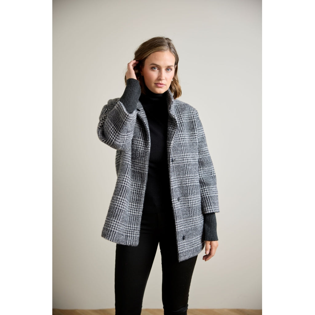 Glen plaid open-front coat with ribbed knit sleeves, worn over black turtleneck and pants