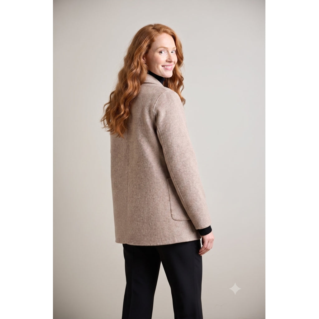 Taupe wool coat with patch pockets shown from back, model looking over shoulder