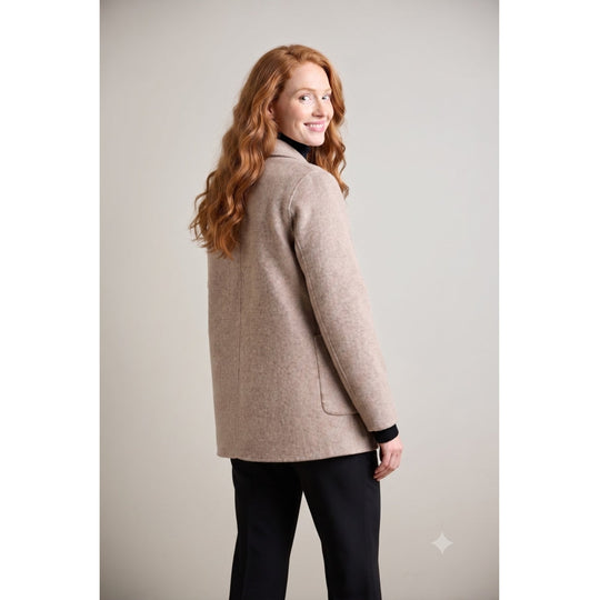 Taupe wool coat with patch pockets shown from back, model looking over shoulder