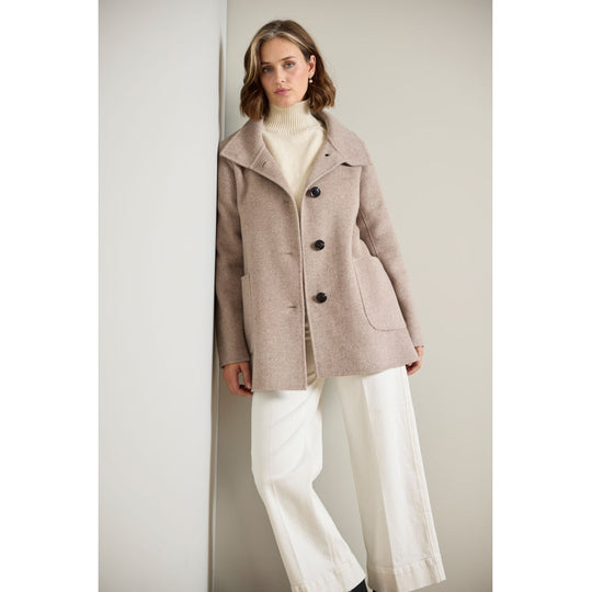 Taupe wool coat with dark buttons, patch pockets, and wide lapels, front view on model
