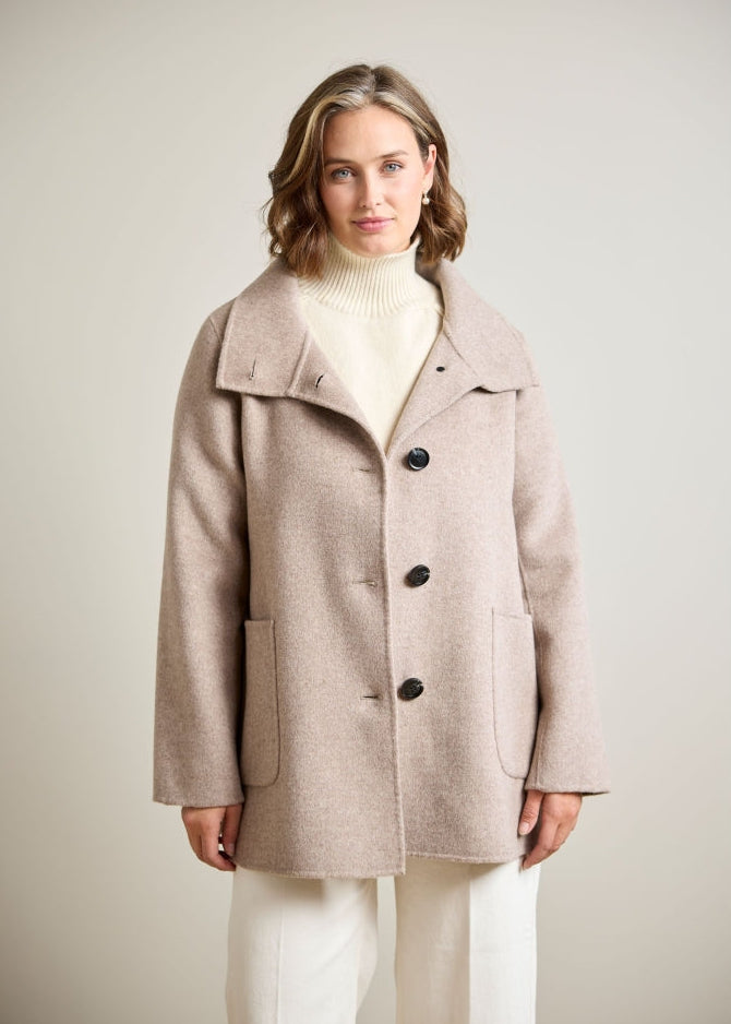 Oversized taupe wool coat with wide lapels, three dark buttons, and patch pockets, front view on model