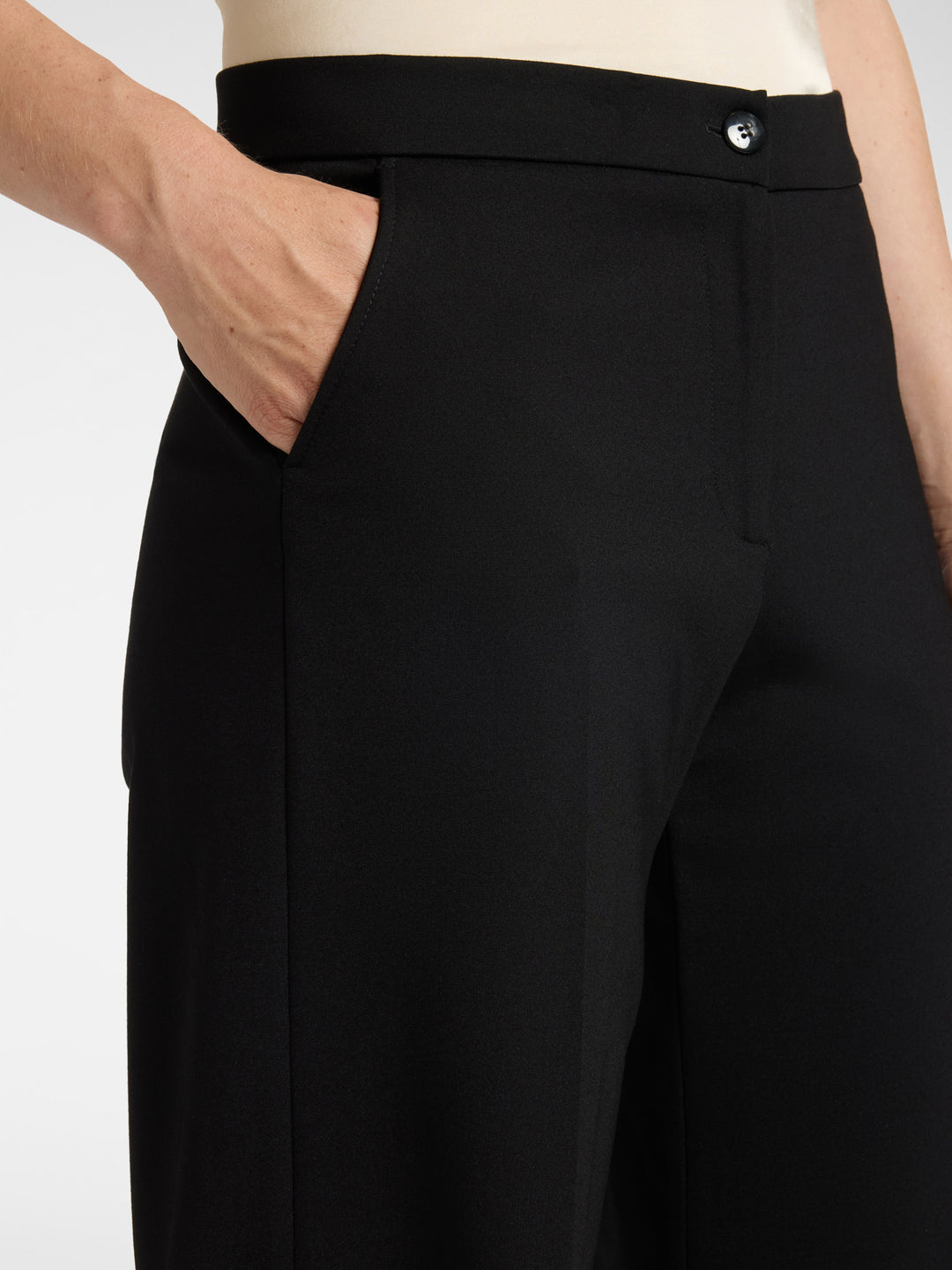 Men's black trouser close-up of waistband button and side pocket
