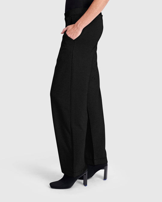 Wide-leg black pull-on pants with pockets, side view on model wearing heeled boots