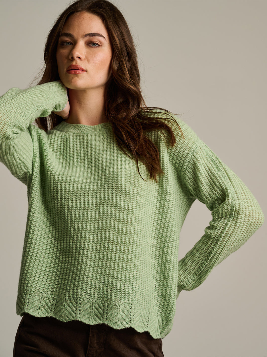 Light green ribbed knit sweater with scalloped hem and long sleeves, front view on model