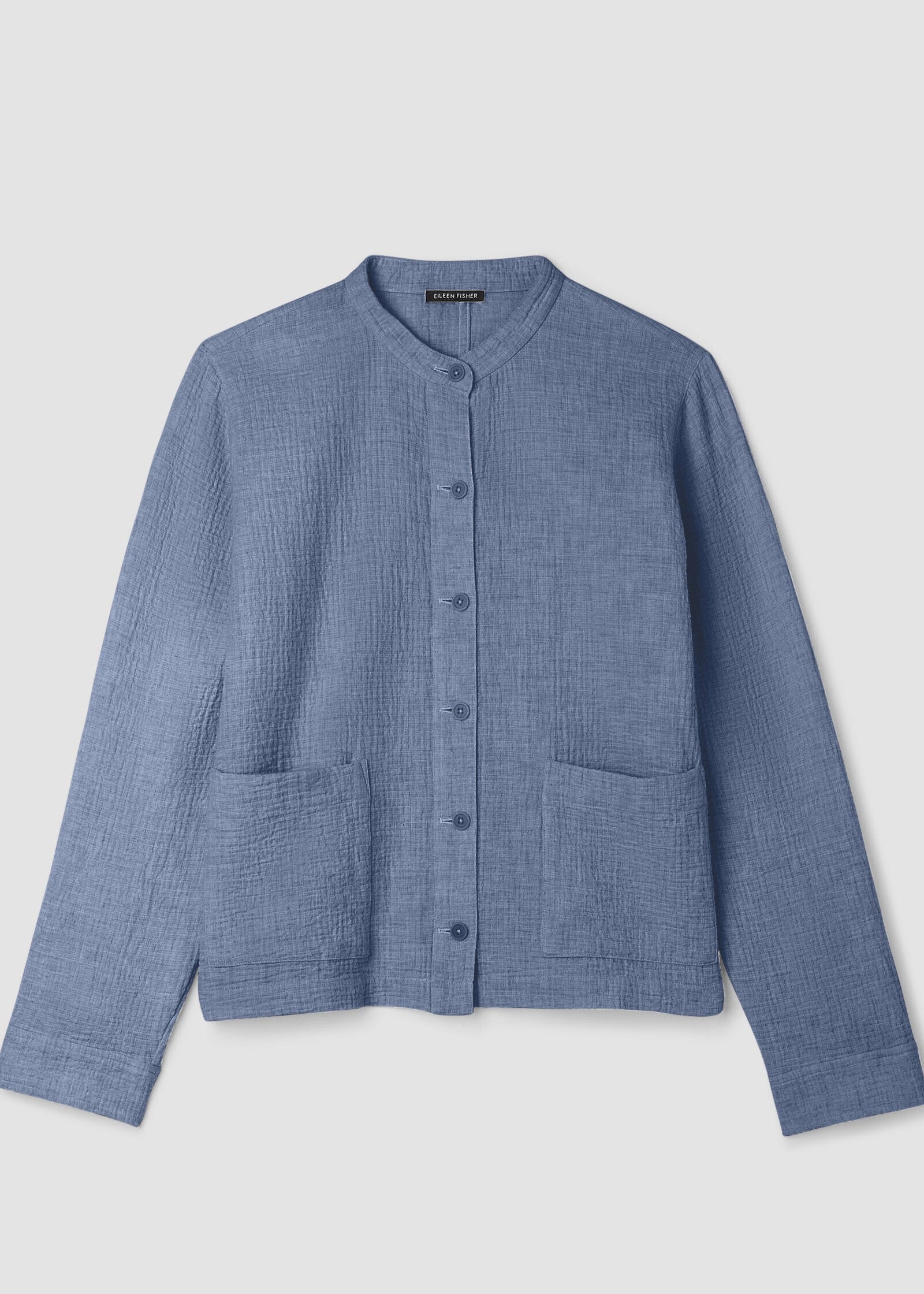 Blue textured shirt with buttons on a light gray background