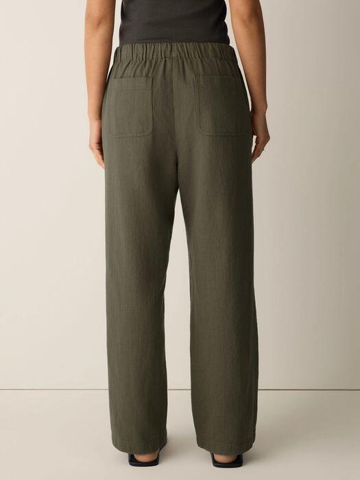 Olive straight-leg pants with elastic waist and side pockets; loose drape