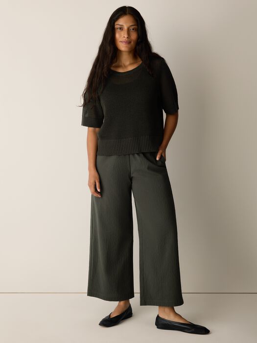 Seaweed green wide-leg ankle pants worn by model, textured pucker fabric