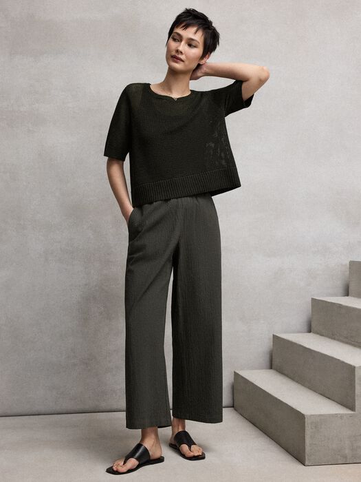 Seaweed green wide-leg ankle pants with pucker texture and elastic waistband on model