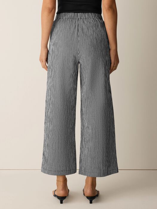 Wide leg ankle pants in black and white check pattern, back view on model