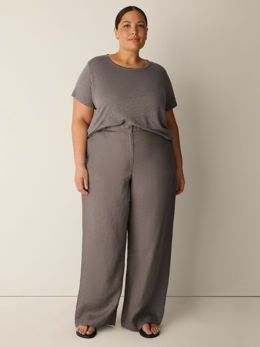 Woman wearing gray wide-leg trousers with matching top, full body front view
