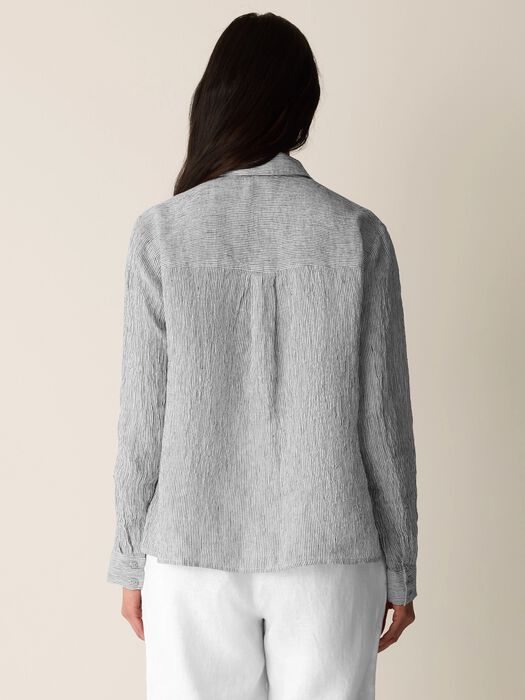 Striped button-up shirt with classic collar shown from back, model wearing white pants