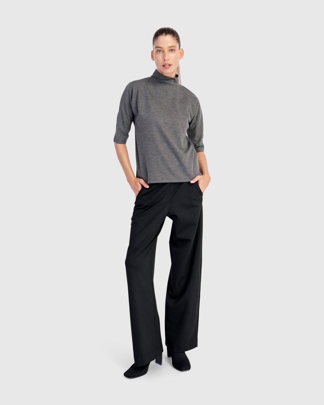 Wide-leg black pull-on trousers with side pockets, worn by a model, front view