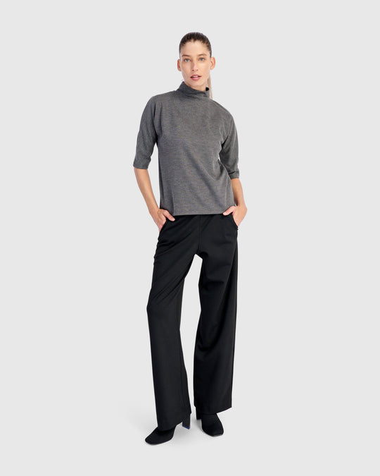 Wide-leg black pull-on trousers with side pockets, worn by a model, front view