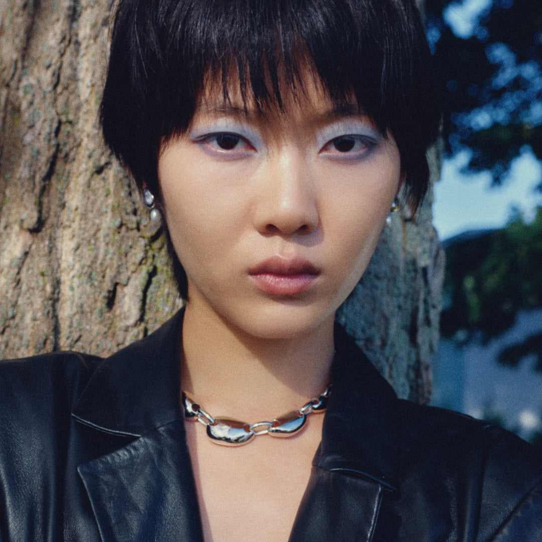 Silver pearl drop earrings worn by model with short dark hair