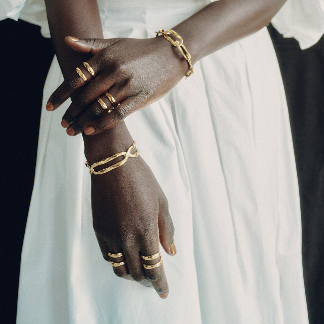 Gold rings worn on fingers with matching bracelets in lifestyle jewelry photo