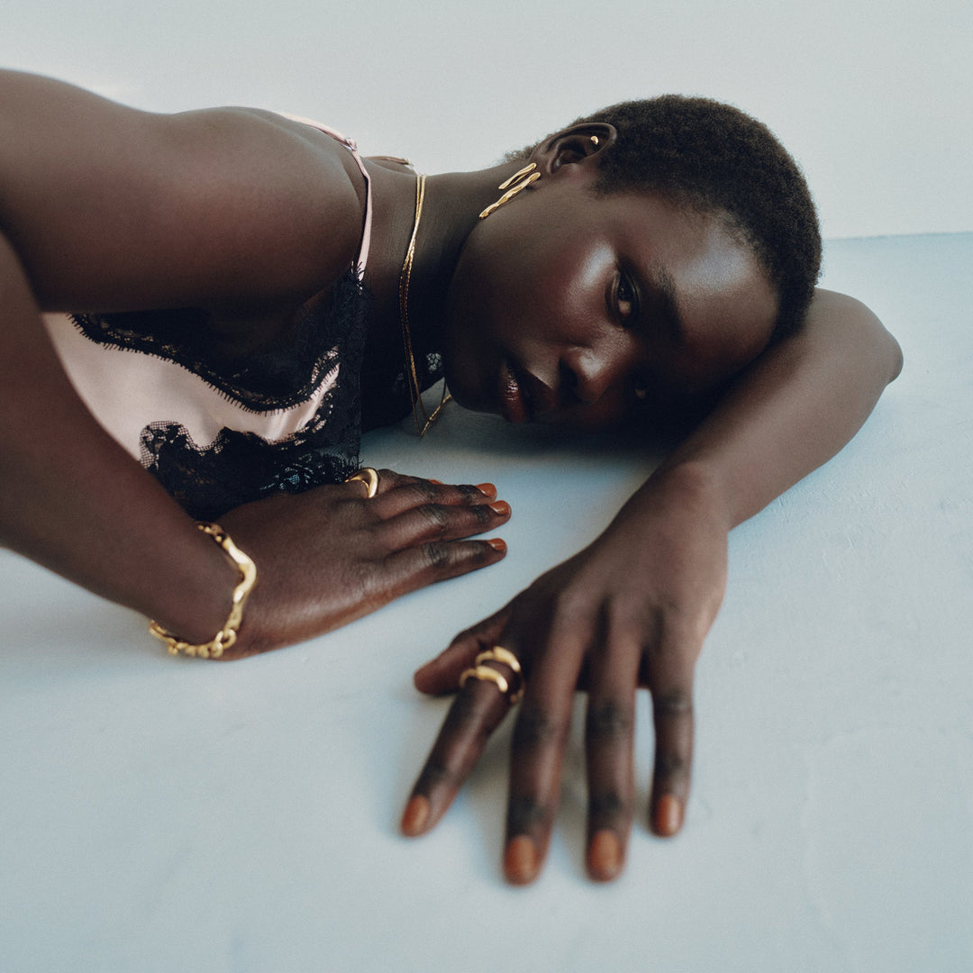 Gold statement rings worn on fingers in artistic lifestyle photography with model