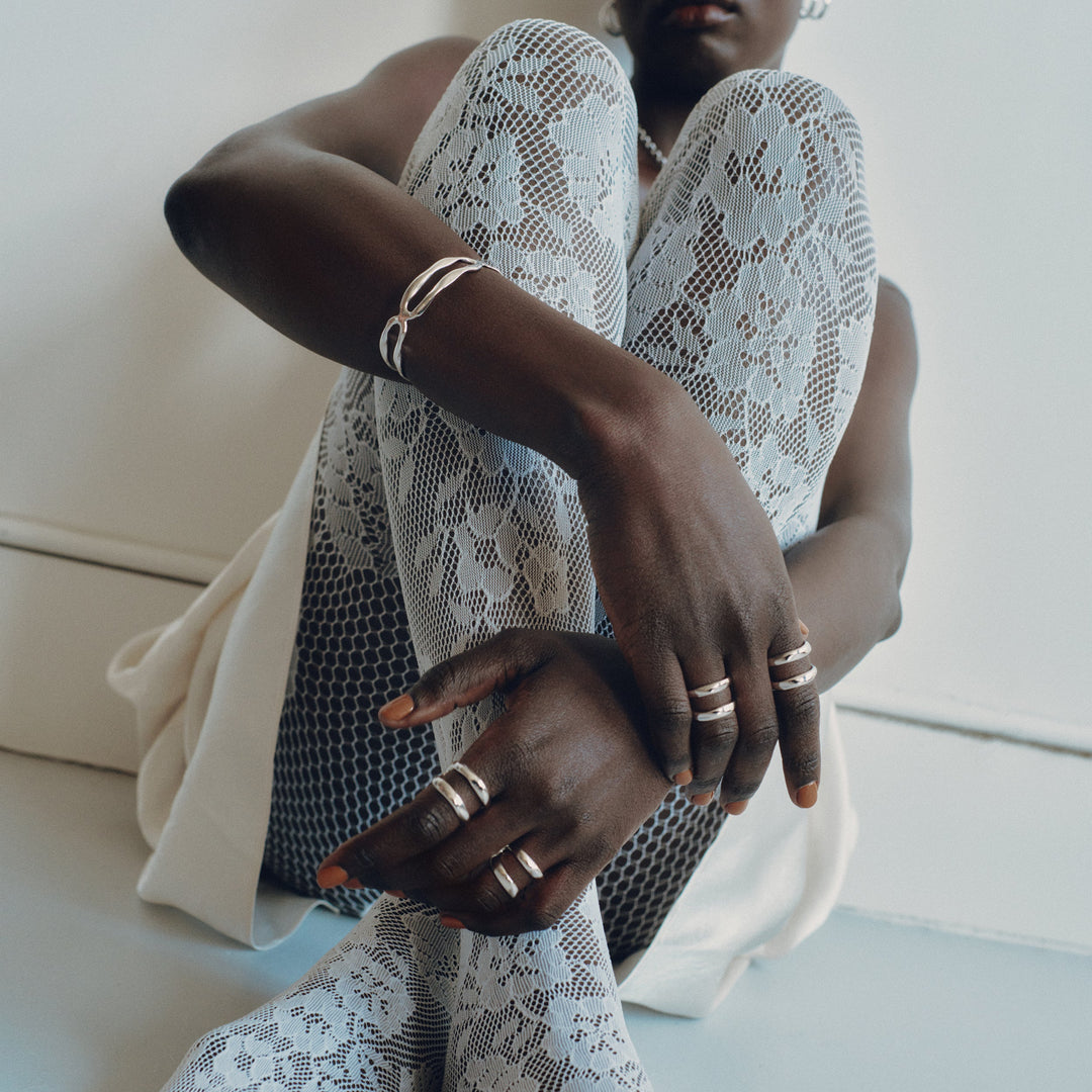Silver stackable rings worn on multiple fingers showing delicate band design