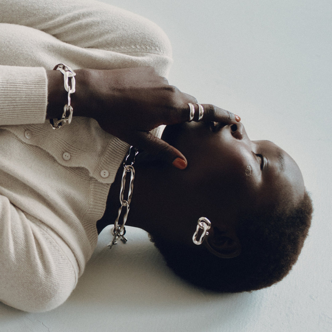 Silver chunky chain rings on model's fingers, lifestyle jewelry photography