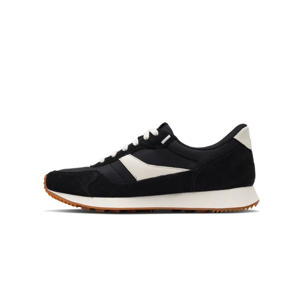 Kizik Siena sneakers, angled view, black upper with white stripe and gum outsole