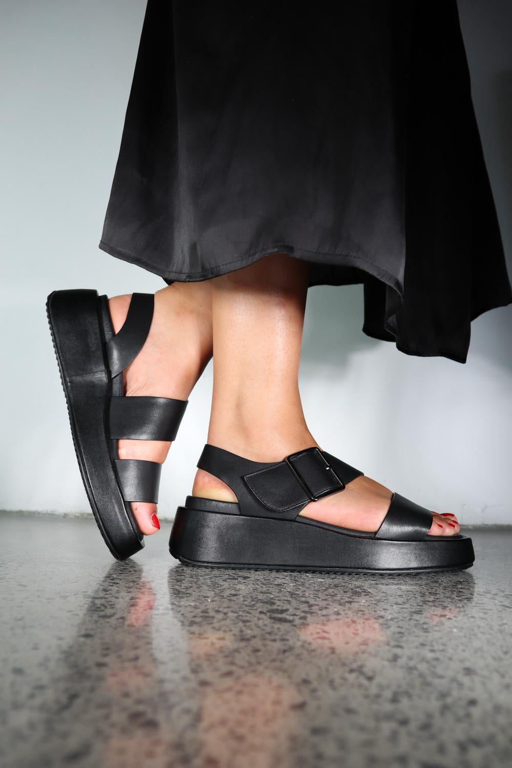 Black platform sandals with velcro straps and chunky sole worn by model
