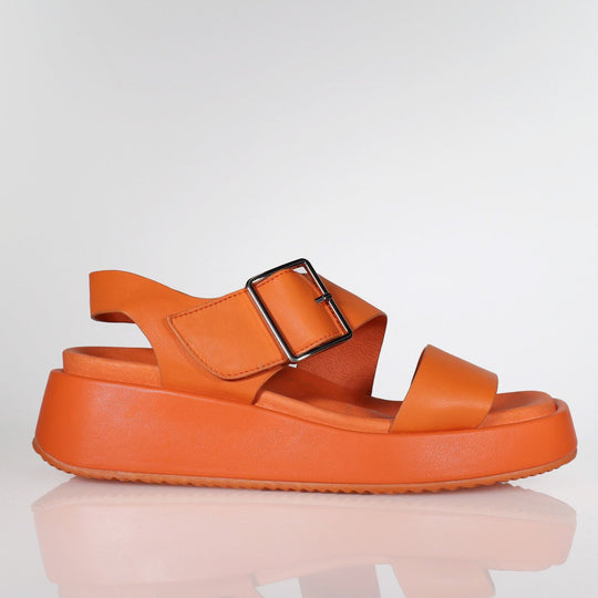 Bright orange platform sandal with velcro strap and chunky sole, side view