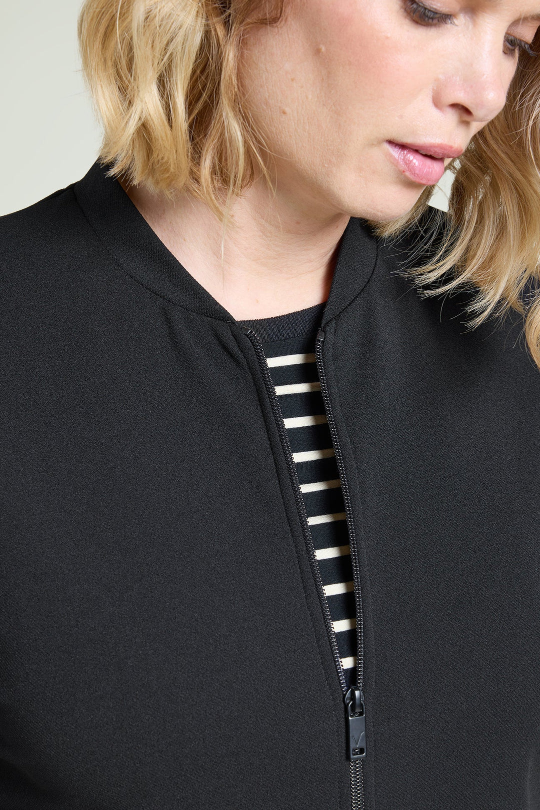 Black zip athleisure jacket with stand collar and visible front zipper