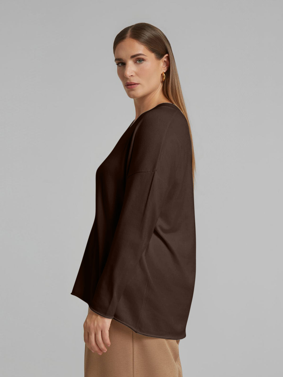 Brown V-neck knit sweater with long sleeves, side profile