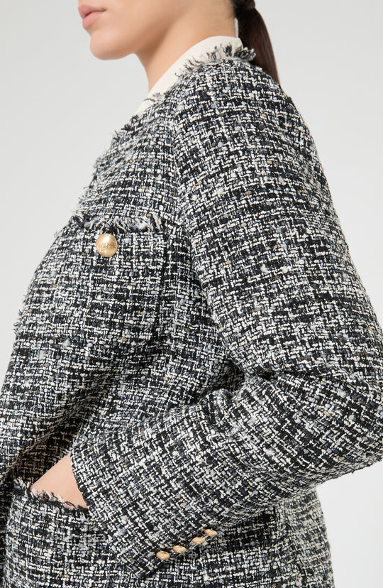 Close-up side view of tweed boucle jacket with gold buttons and frayed trim details