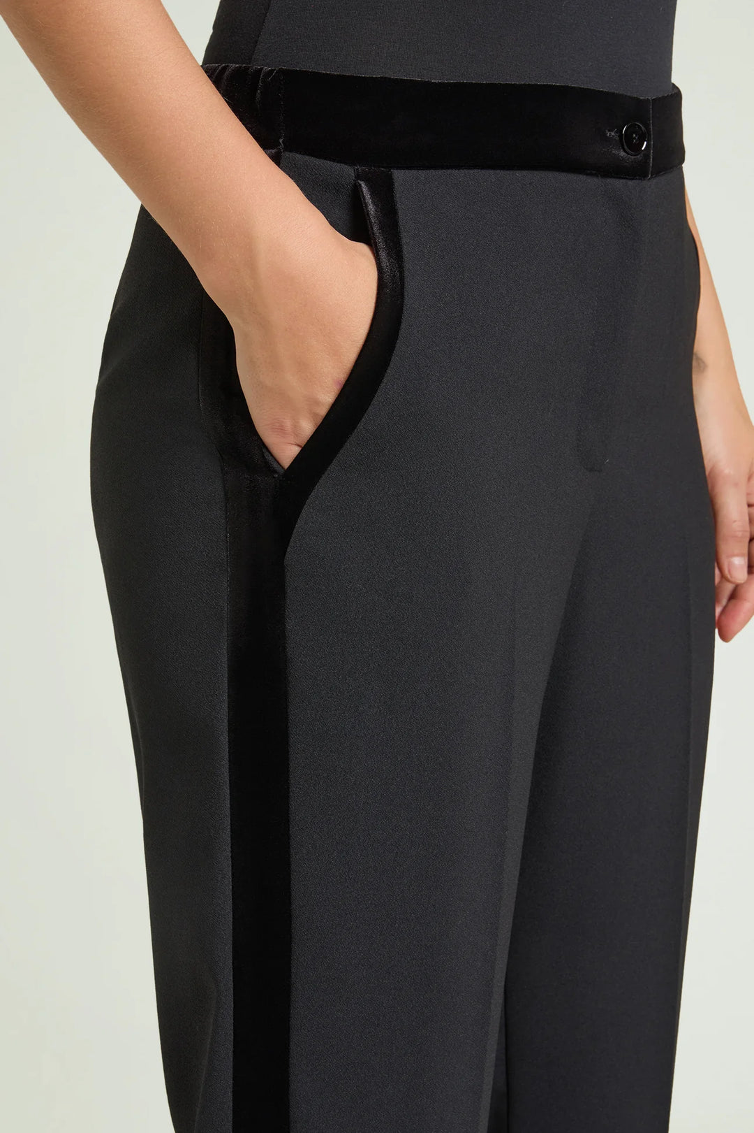 Black crepe tuxedo pants close-up showing side velvet stripe and front crease